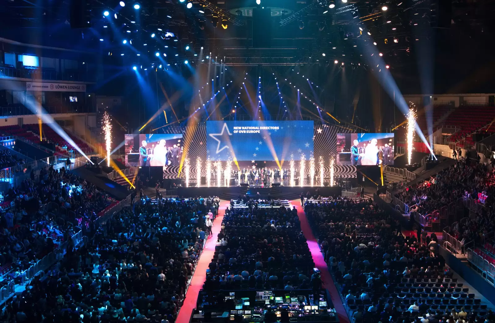 Volle Arena im PSD Bank Dome Düsseldorf mit Lichtstrahlen, Funkenfontänen und einem roten Laufsteg zur Bühne, auf der Leinwand ein großer Stern