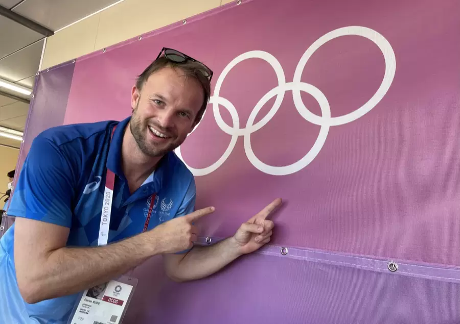 Florian Rudig lacht und zeigt auf die Olympischen Ringe bei den Spielen in Tokio Florian Rudig lacht und zeigt auf die Olympischen Ringe bei den Spielen in Tokio