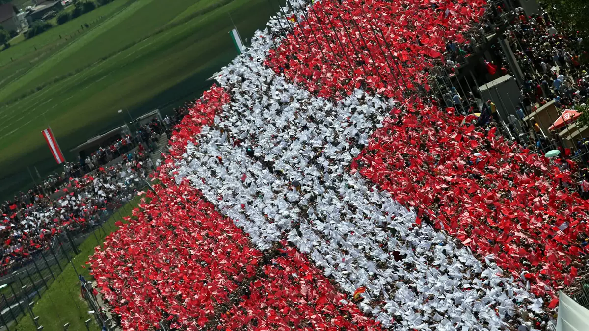 Luftaufnahme der Tribüne am Red Bull Ring, Fans bilden eine riesige rot-weiß-rote Österreich-Fahne Luftaufnahme der Tribüne am Red Bull Ring, Fans bilden eine riesige rot-weiß-rote Österreich-Fahne