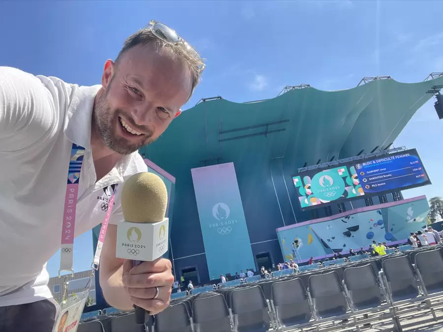 Florian Rudig mit Mikrofon und Akkreditierung vor der Kletterarena der Olympischen Spiele Paris 2024 in Le Bourget Florian Rudig mit Mikrofon und Akkreditierung vor der Kletterarena der Olympischen Spiele Paris 2024 in Le Bourget