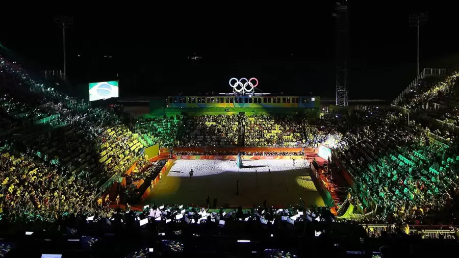 Das voll besetzte Beachvolleyball-Stadion an der Copacabana bei Nacht, über dem Court die Olympischen Ringe Das voll besetzte Beachvolleyball-Stadion an der Copacabana bei Nacht, über dem Court die Olympischen Ringe
