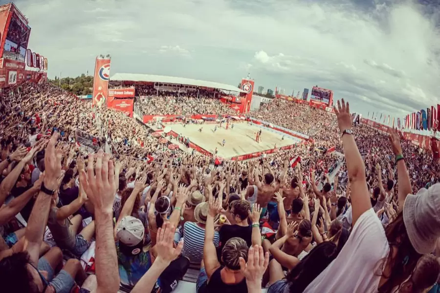 Voll besetztes Beachvolleyball-Stadion am Wiener Heumarkt, die Fans reißen die Arme in die Höhe Voll besetztes Beachvolleyball-Stadion am Wiener Heumarkt, die Fans reißen die Arme in die Höhe